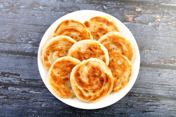 Plate of delicious parathas  on a wooden background,