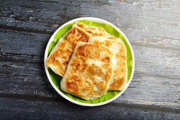 Stack of crispy and soft north Indian paratha with a crispy crust .
