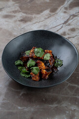 A sumptuous plate of expertly prepared food showcases a blend of textures and flavors topped with fresh herbs. This exquisite dish invites diners to indulge in their culinary journey