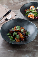 A delightful culinary experience unfolds as fresh European dishes are artfully presented in elegant black bowls, surrounded by a stylish dining ambiance. Guests enjoy the artistry of the meal