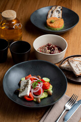 Enjoy a vibrant spread of European dishes featuring a fresh salad, rich spreads, and expertly paired drinks on a warm wooden table, creating an inviting atmosphere