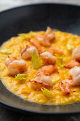 A gourmet dish showcasing creamy risotto adorned with perfectly grilled shrimp and fresh herbs invites diners to indulge in an exquisite European culinary experience at dinner