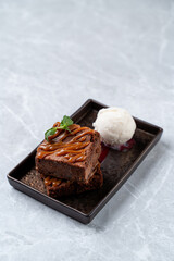 Enjoy a moist chocolate brownie drizzled with caramel and a scoop of creamy vanilla ice cream—perfect for a relaxing evening at a European-style restaurant