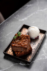 Savor a delicious dessert: moist chocolate cake layered with warm caramel and a scoop of creamy vanilla ice cream, all in a charming European restaurant