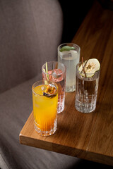 Three distinct glasses filled with vibrant beverages rest on a wooden table. Each drink showcases unique flavors, inviting patrons to indulge in a delightful culinary experience