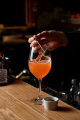 A mixologist expertly prepares a vibrant cocktail at a European restaurant, showcasing artistic flair and a passion for flavor. The atmosphere is warm and inviting