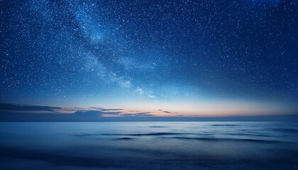 starry night sky in blue hues above a serene ocean seascape with ample copy space image
