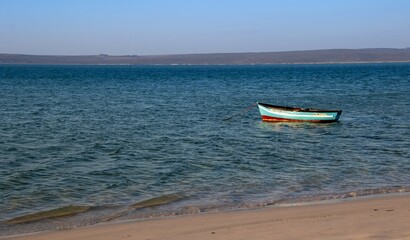 A small wood boat on a mooring in a lagoon