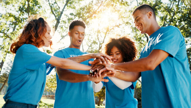 Volunteer, team and people huddle outdoor for support, donation goal or cooperation in low angle. Hands together, community service or group with motivation for NGO, smile or collaboration at charity