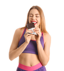 Young woman eating sweet chocolate bar on white background