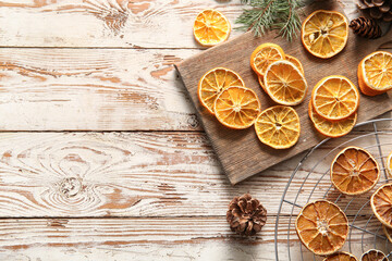 Stand and board with dried orange slices on white wooden background