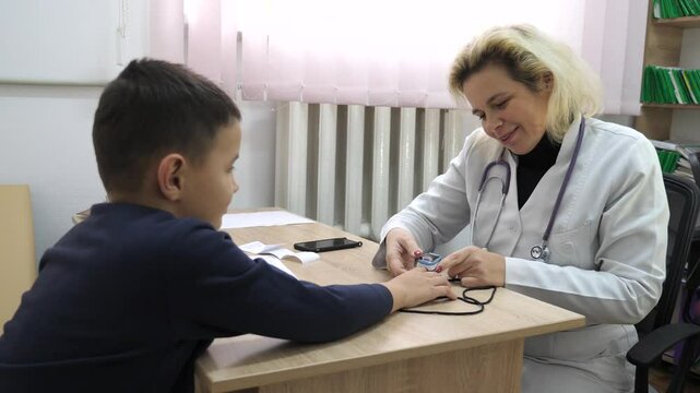 Doctor measures boy's oxygen saturation. Medical examination.