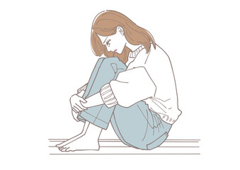 体育座りで落ち込んでいる若い女性