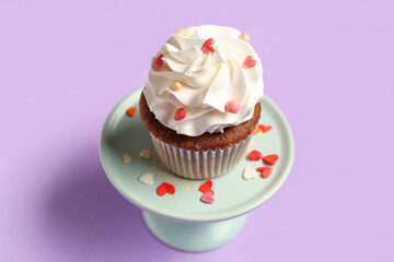 Stand with tasty cupcake for Valentine's Day on purple background