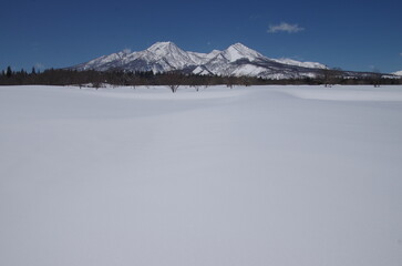青空の下　雪原の向こうにそびえたつ妙高山