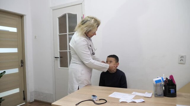 A doctor feels a boy's adenoids. Medical examination.