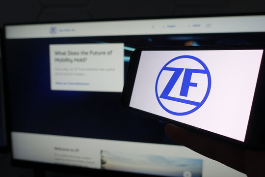 Kiel, SH, Germany March 19 2025: Smartphone with the logo of ZF Company in front of a monitor displaying their business website focused on mobility technology advancements