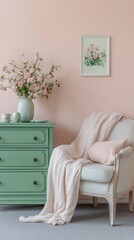 A tranquil nook showcases a soft armchair draped with a cozy blanket, complemented by a mint green dresser and delicate floral decor, all set against a warm peach wall