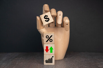 sztuczna ręka układa kostki z logotypami dotyczącymi finansów 