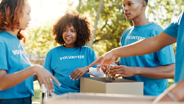 People, volunteer and boxes of donation at park for giving food, packing supplies and community aid. Staff, helping and sorting products for charity outreach, teamwork and distribution of NGO welfare - Powered by Adobe