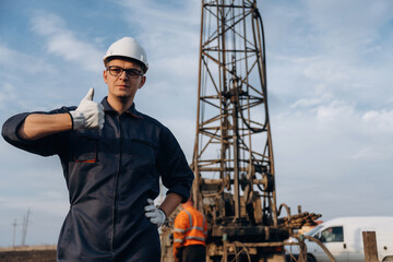 Thumb up gesture. Construction worker is near boring drilling machine