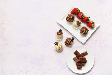 Plate with chocolate covered strawberries and fresh berries on white background