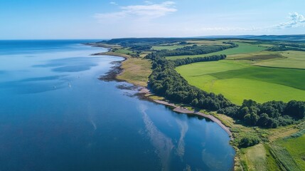 Aerial view of coastal landscape with lush green fields and serene blue waters