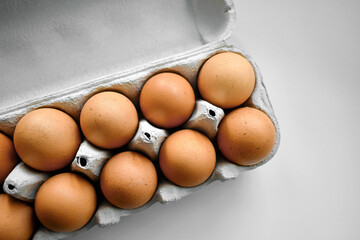 Eggs in carton box on the table. Top view flat lay.