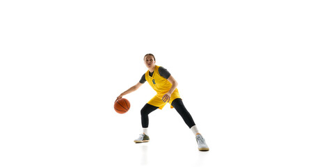 Obraz premium Women, basketball player in yellow jersey and black shorts in motion with ball, showing agility isolated on white background. Concept of sport, competition, game, action, active lifestyle. Ads