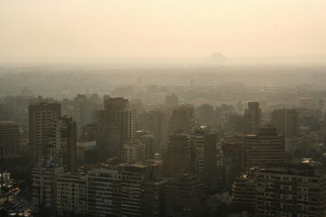 Residential buildings of Cairo and Pyramids of Giza in a haze at background as seen from Cairo TV Tower. Western Cairo and Giza cityscape