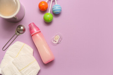 Bottle with baby milk formula, pacifier, diapers and rattle on lilac background