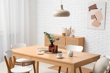 Table with teapot and cups in interior of dining room