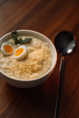 millet porridge with egg in a white bowl on a dark background