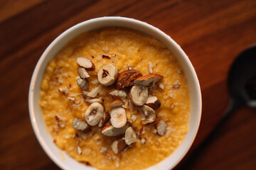 corn porridge with nuts in a white bowl, vertical photo