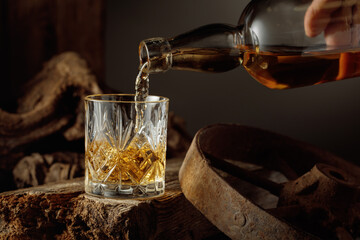Whiskey is poured from a bottle into a glass.