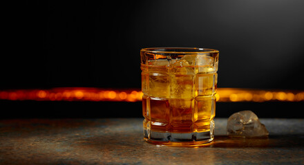 Whiskey with ice on a dark background.