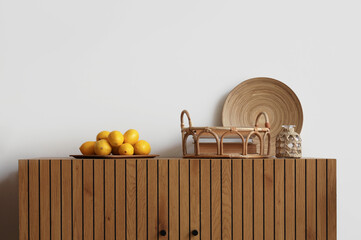 Lemons and tray with books on commode near light wall