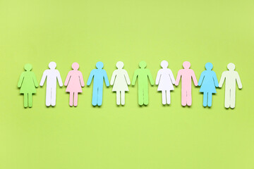 Colorful paper human figures on green background. Diversity and inclusion concept