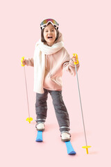 Little Asian girl skiing on pink background