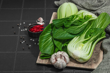 Fresh Bok choy on a trendy black tile background. Traditional Chinese cabbage vitamin ingredient