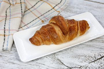kruvasan cup of coffee and croissant on a rustic white wooden	