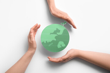 Female hands with paper planet Earth on white background. World Earth Day celebration