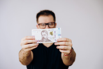 The man with the glasses is holding the bucks.