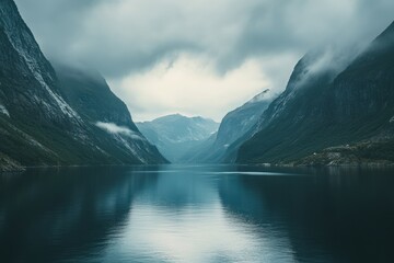 Majestic fjord reflecting serene mountains under moody skies at dawn