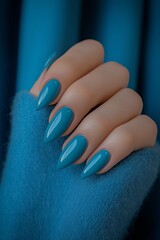Close-up of woman's hand showcasing fashion trends in manicure with long, pointed, teal-colored nails. Concept: exploring fashion trends in manicure from salon perspective.
