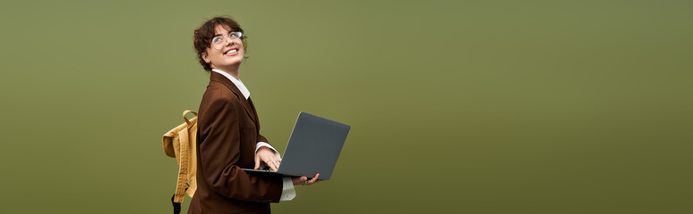 Young woman confidently showcasing her style while working on her laptop in a vibrant setting