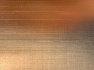 The gradient color of the copper background is like fine fabric, with horizontal lines and a golden hue. The light shines on it from above, creating a warm atmosphere.