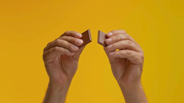 SLO MO LD Male hands breaking apart a piece of chocolate