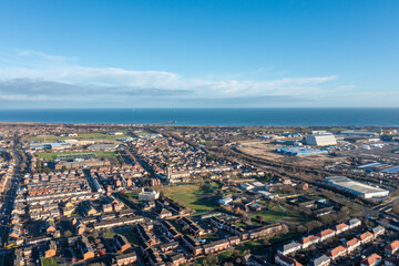 Aerial drone photo of the town of Hartlepool in the UK showing rows of terrace houses and homes and typical British suburban housing estates with the ocean in the background in the winter time