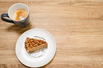Caramel Almond Toffee Cake with hot coffee. Brown needle coffee cake in a separate container on a wooden table from above	
